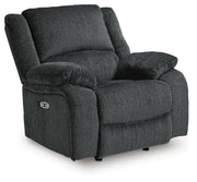Ashley Furniture Draycoll power recliner in dark fabric with plush cushions, shown from an angled side view.