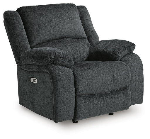 Ashley Furniture Draycoll power recliner in dark fabric with plush cushions, shown from an angled side view.