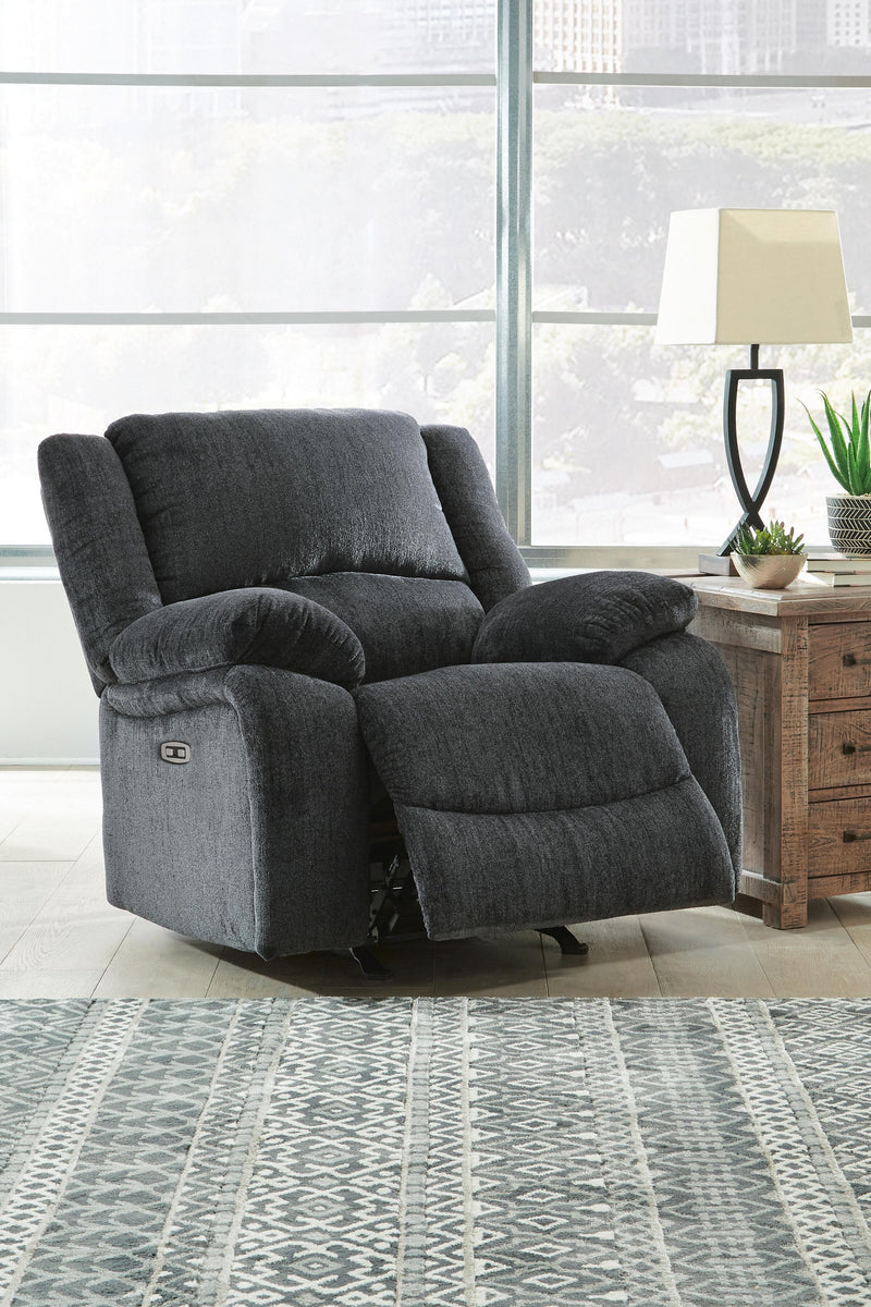 Open Ashley Furniture Draycoll power recliner showing plush fabric, padded armrests, and reclining mechanism in a cozy living room setting.