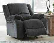 Open Ashley Furniture Draycoll recliner showing plush fabric upholstery and reclining mechanism, designed for comfortable seating.