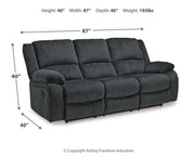 Ashley Furniture Draycoll reclining sofa with plush cushions and a dark fabric finish, designed for comfortable lounging.