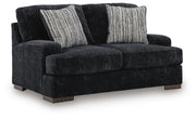 Ashley Furniture Whitmore Manor loveseat with plush fabric and classic design, shown from an angled side view.