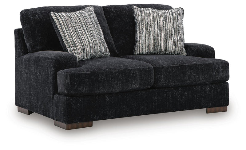 Ashley Furniture Whitmore Manor loveseat with plush fabric and classic design, shown from an angled side view.