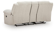 Ashley Furniture Orlen reclining loveseat with built-in console, featuring plush fabric and cushioned armrests for comfortable seating.