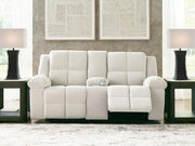 Ashley Furniture Orlen reclining loveseat with built-in console, shown open with plush cushions and armrests in a modern living room setting.