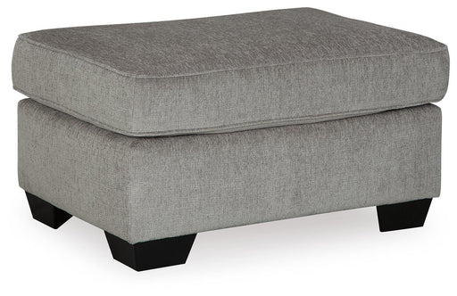 Ashley Furniture Altari Ottoman with a soft fabric cushion and wooden legs, shown from an angled side view.