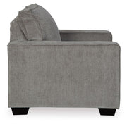 Ashley Furniture Altari Chair with beige upholstery and wooden legs, shown from a side angle in a modern living room setting.