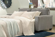 Ashley Furniture Altari Sleeper Sofa in neutral fabric, showcasing its fold-out bed and modern design in a living room setting