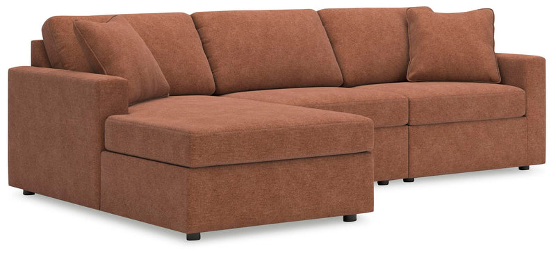 Ashley Furniture Modmax sectional with chaise, featuring plush cushions and modern design in a stylish living room setting.