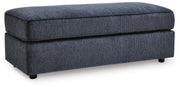 Ashley Furniture Albar Place oversized accent ottoman with plush fabric and wooden legs, shown from an angled side view.