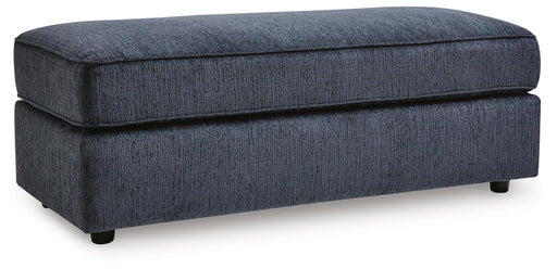 Ashley Furniture Albar Place oversized accent ottoman with plush fabric and wooden legs, shown from an angled side view.