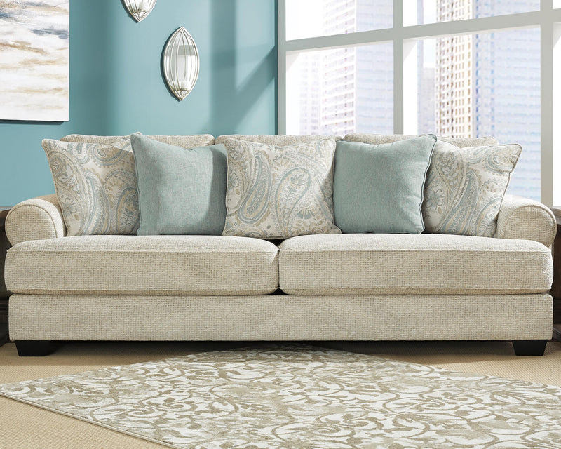 Ashley Furniture Monaghan living room set featuring a sofa and loveseat with neutral upholstery and wooden legs.