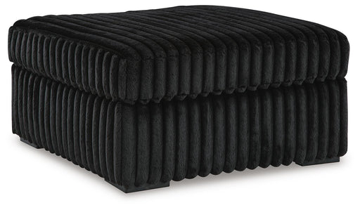 Ashley Furniture Midnight-Madness oversized accent ottoman with plush fabric and modern design, shown from an angled view.