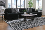 Ashley Furniture Midnight-Madness sectional with chaise, featuring plush fabric and modern design, shown in a stylish living room setting.