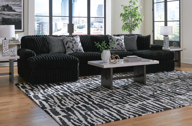 Ashley Furniture Midnight-Madness sectional with chaise, featuring plush fabric and modern design, shown in a stylish living room setting.