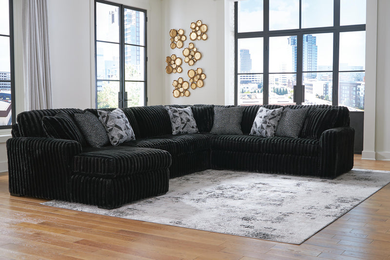 Ashley Furniture Midnight-Madness sectional with chaise, featuring plush upholstery and modern design in a stylish living room setting.