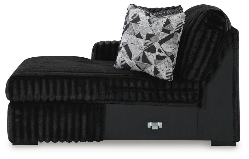 Ashley Furniture Midnight-Madness sectional with chaise, showing dark fabric upholstery and modern design in a spacious living room.