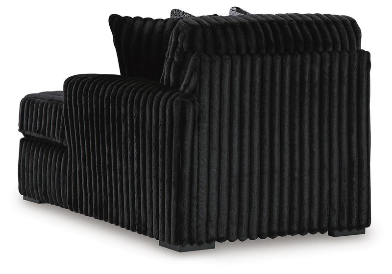 Ashley Furniture Midnight-Madness sectional with chaise, showcasing plush fabric, modern design, and comfortable seating arrangement.