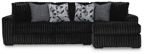 Ashley Furniture Midnight-Madness sectional sofa with chaise, featuring plush upholstery and modern design, shown in a living room setting.