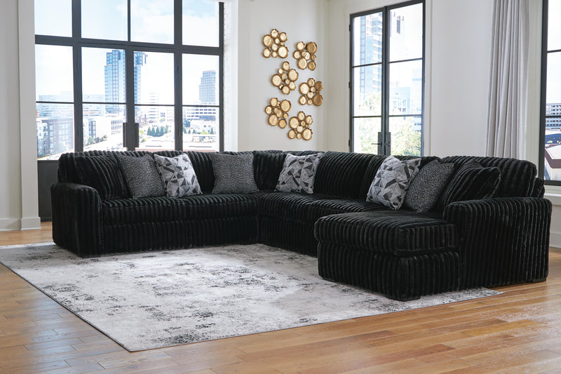 Ashley Furniture Midnight-Madness sectional with chaise, showing plush fabric, modern design, and spacious seating arrangement.