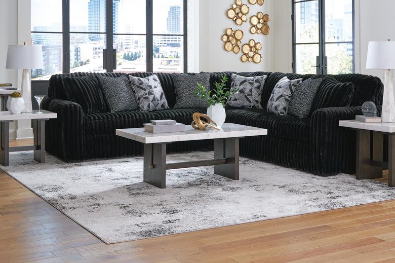 Ashley Furniture Midnight-Madness sectional sofa with plush cushions and dark fabric upholstery, arranged in a spacious living room setting.