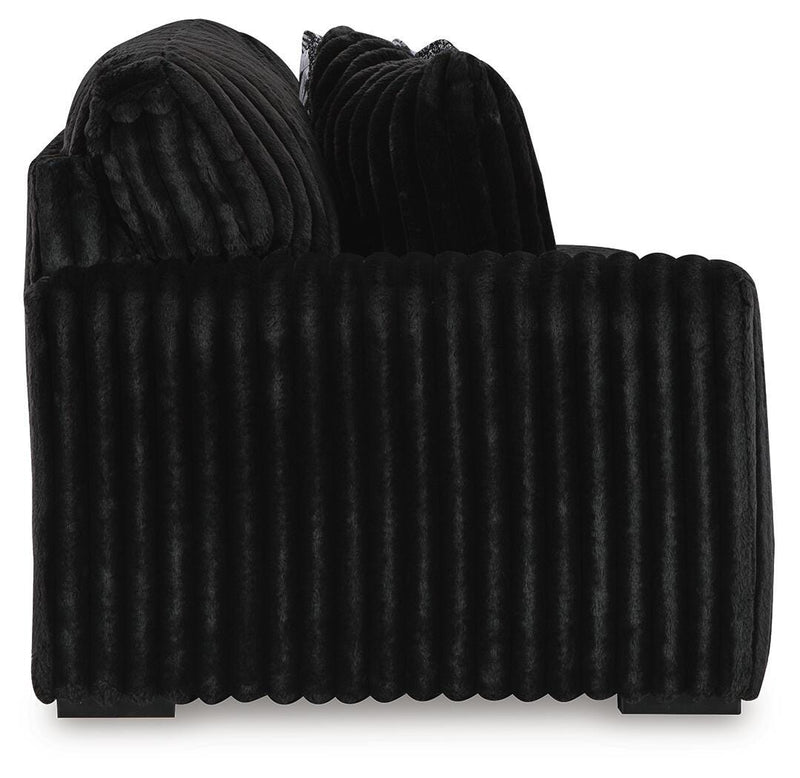 Ashley Furniture Midnight-Madness Sectional sofa with dark fabric and plush cushions, shown from a side angle.