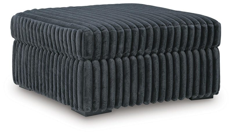 Ashley Furniture Midnight-Madness oversized accent ottoman with plush fabric and modern design, viewed from an angled perspective.