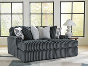 Ashley Furniture Midnight-Madness Super Chaise sectional with plush cushions and dark upholstery in a modern living room setting.