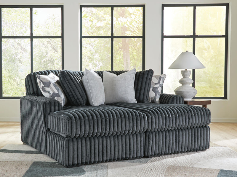 Ashley Furniture Midnight-Madness Super Chaise sectional with plush cushions and dark upholstery in a modern living room setting.