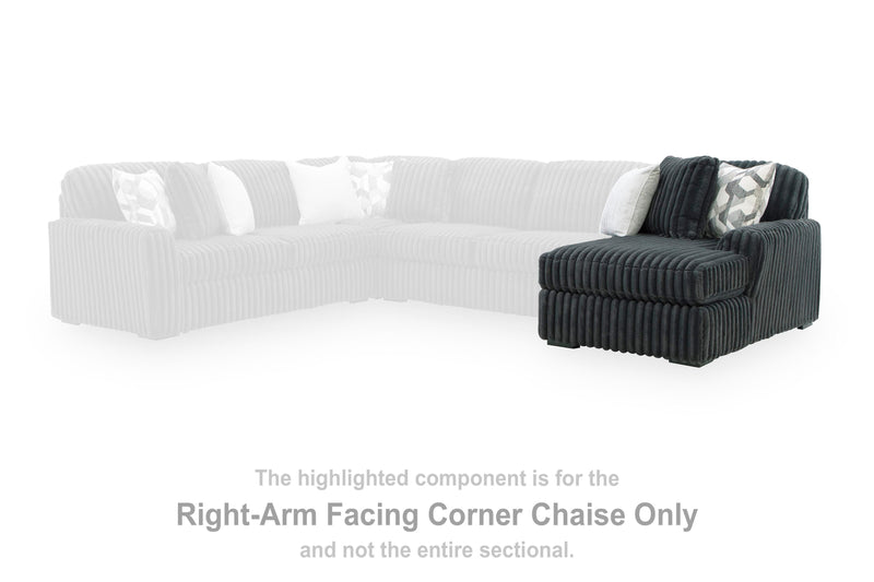 Ashley Furniture Midnight-Madness sectional with chaise, dark fabric, and plush cushions in a modern living room setting.
