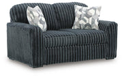 Ashley Furniture Midnight-Madness loveseat shown from an angled view, featuring plush fabric and stylish design for cozy living spaces.