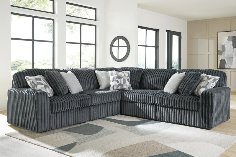 Ashley Furniture Midnight-Madness sectional in dark upholstery with plush cushions and modern design, shown in a living room setting.