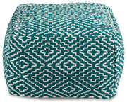 Ashley Furniture Brynnsen pouf featuring soft fabric upholstery and a modern round design, shown from a head-on angle.