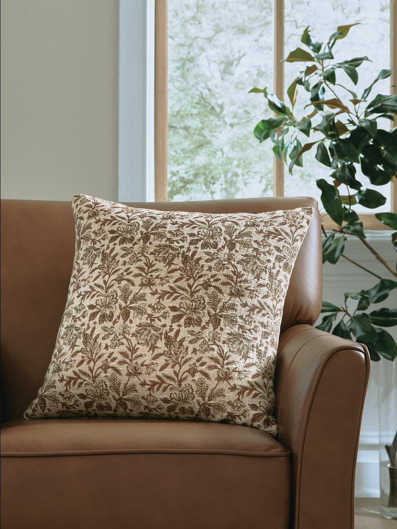 Set of four Ashley Furniture Altmontner pillows with soft fabric covers and decorative stitching, arranged on a cozy sofa.