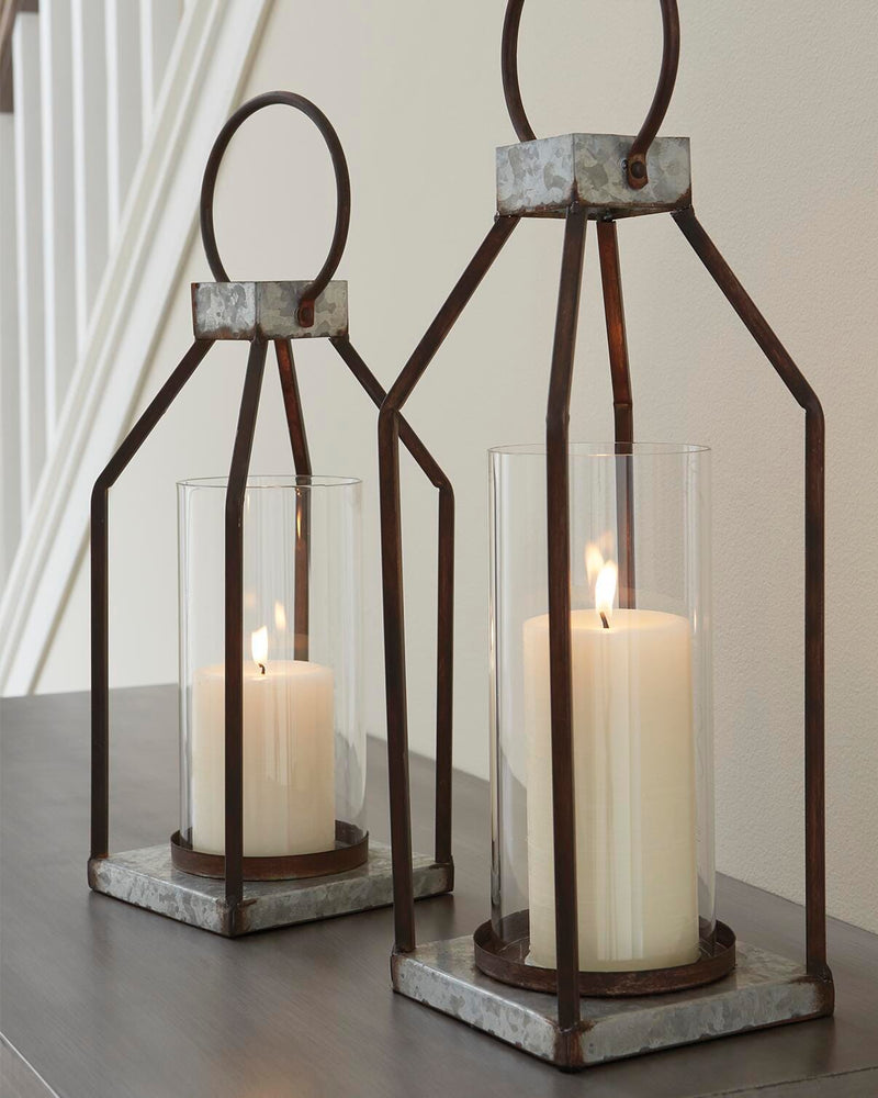 Set of two Diedrick Lantern candle holders by Ashley Furniture with glass panels and metal frames on a wooden surface.