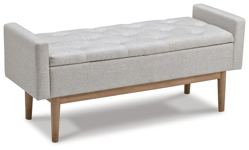 Ashley Furniture Briarson Storage Bench with cushioned top and wooden legs, shown from an angled side view.