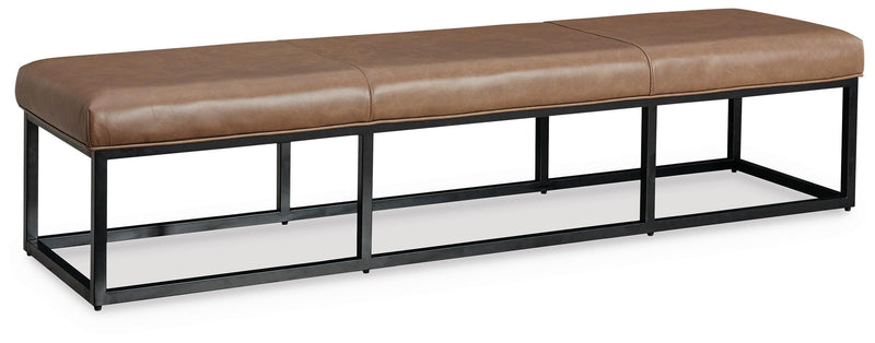 Ashley Furniture Joston accent bench with wooden legs and upholstered seat, shown from an angled side view.