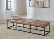 Ashley Furniture Joston accent bench with wooden legs and upholstered seat, ideal for entryways or living rooms.