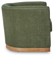 Ashley Furniture Jersonlow swivel accent chair with plush upholstery and wooden legs, shown from a side angle.