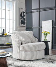 Ashley Furniture Gramwell swivel accent chair with plush upholstery and wooden legs, positioned in a modern living room setting.