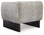 Ashley Furniture Olethea accent chair with plush upholstery and sleek wooden legs, shown from the back in a modern living room setting.