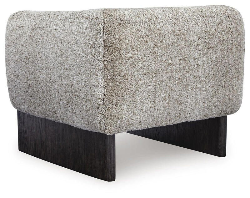Ashley Furniture Olethea accent chair with plush upholstery and sleek wooden legs, shown from the back in a modern living room setting.