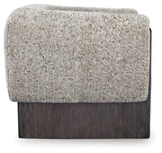 Ashley Furniture Olethea accent chair with plush fabric and wooden legs, shown from a side angle in a modern living room setting.