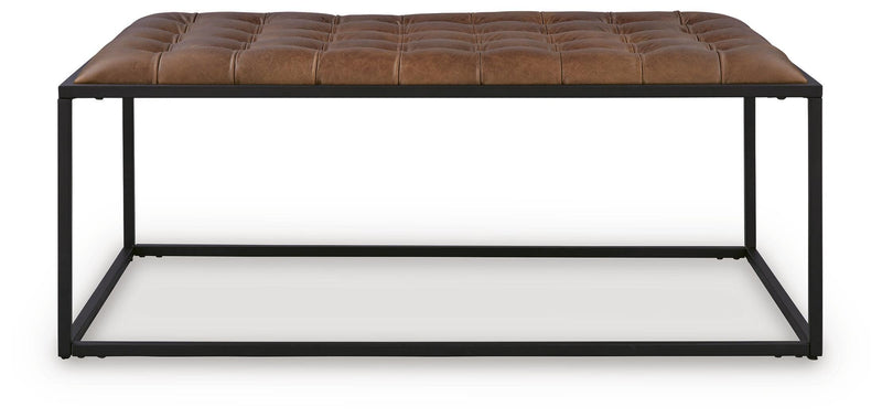 Ashley Furniture Junsor coffee table ottoman with a cushioned top and wooden legs, perfect for living room decor.