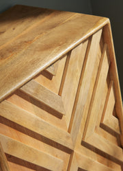 Close-up of the detailed door of the Ashley Furniture Cadewick Accent Cabinet showing its elegant wood grain and decorative hardware.