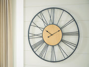 Ashley Furniture Brockett wall clock with a round face and modern design, mounted on a plain background.