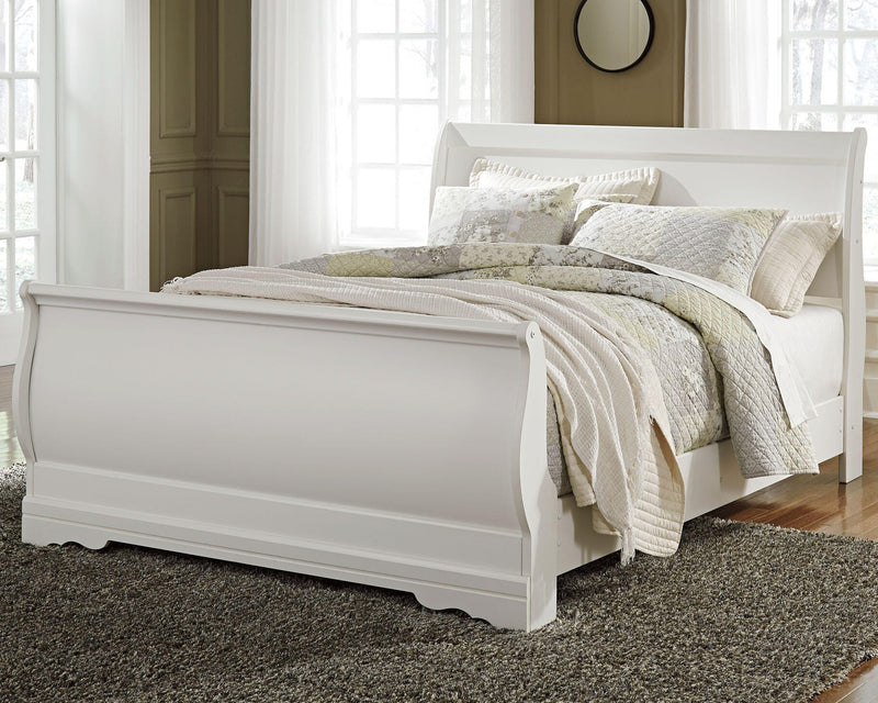 Ashley Furniture Anarasia Bed with upholstered headboard and wood frame, shown in a cozy bedroom setting.