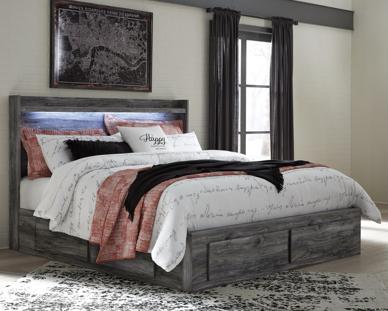 Ashley Furniture Baystorm storage bed with built-in drawers and upholstered headboard, shown in a cozy bedroom setting.