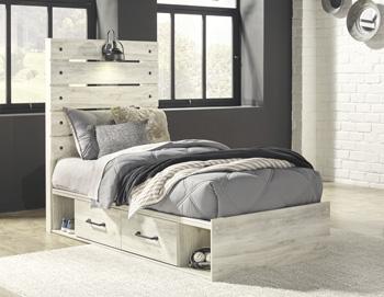 Ashley Furniture Cambeck Bed with 4 storage drawers, featuring a modern wood finish and built-in storage for bedroom organization.