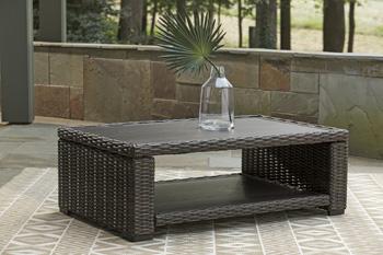 Ashley Furniture Grasson Lane outdoor occasional table set with two stylish tables and matching chairs in a garden setting
